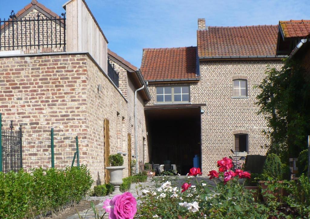 ein Backsteinhaus mit Garage und ein paar Blumen in der Unterkunft B&B Kamer en Aambeeld in Zoutleeuw