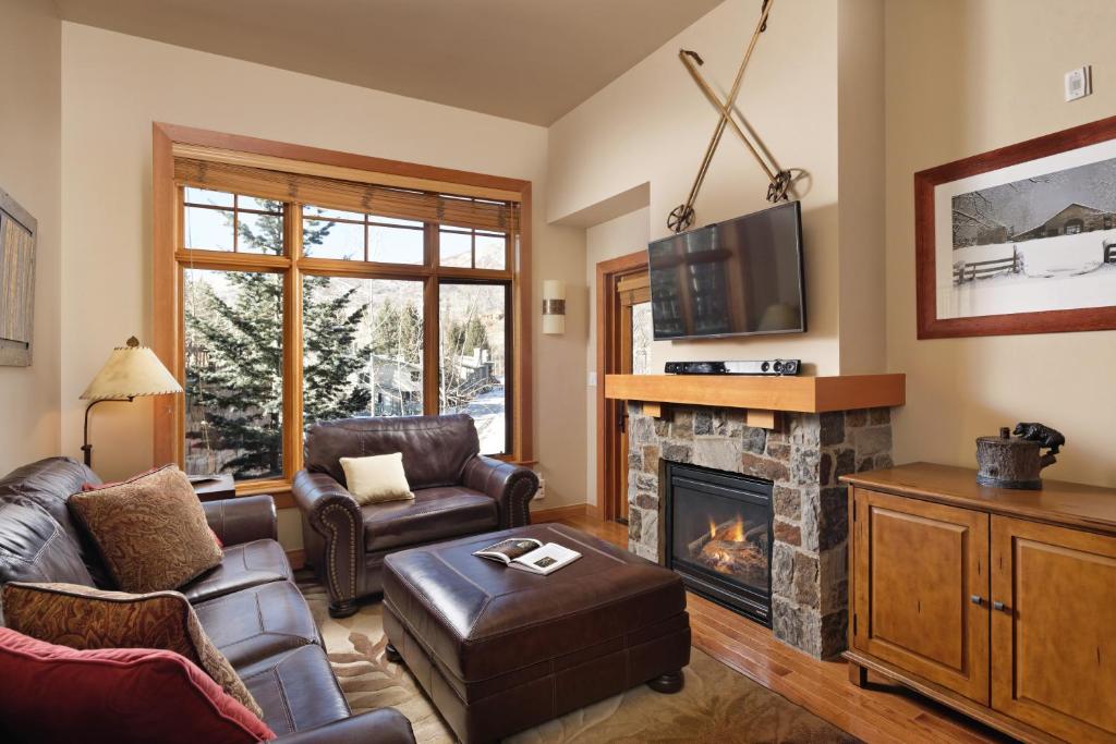a living room with a fireplace and a tv at Alpine Luxury Escape At Capitol Peak Lodge in Snowmass Village