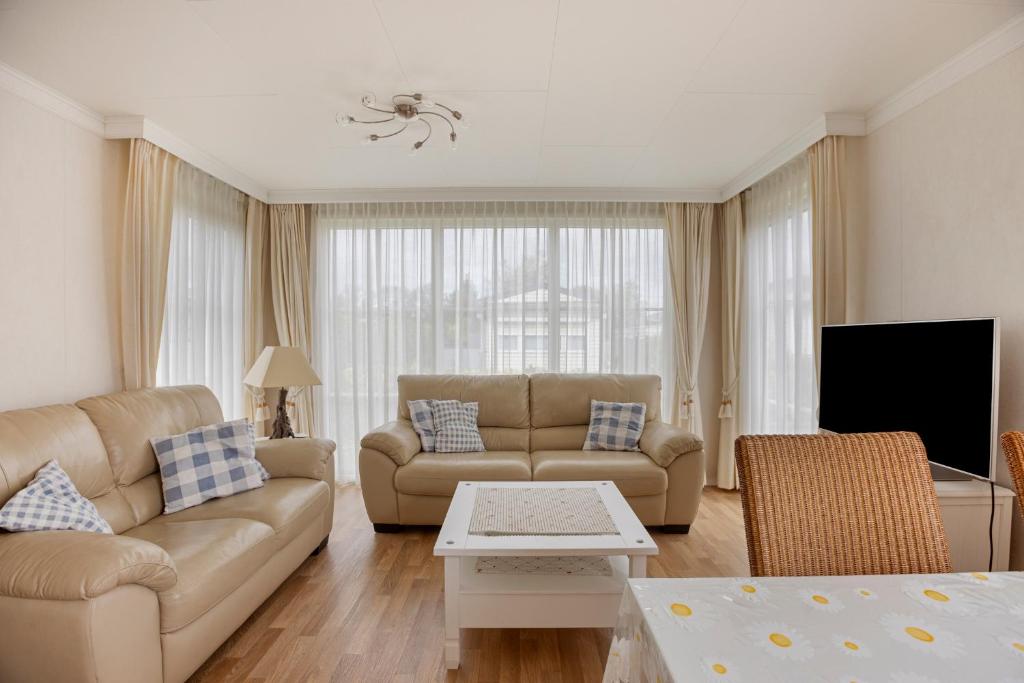 a living room with a couch and a tv at Polderpark 190 in Nieuwpoort