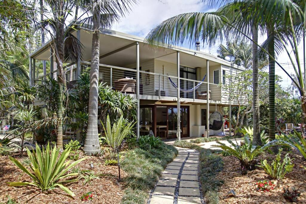 a house with palm trees in front of it at Jimmy's Beach House in Byron Bay
