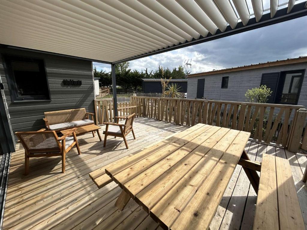 una terraza de madera con mesa y banco en Chalet Jullouville, 4 pièces, 6 personnes - FR-1-361-474 en Jullouville-les-Pins