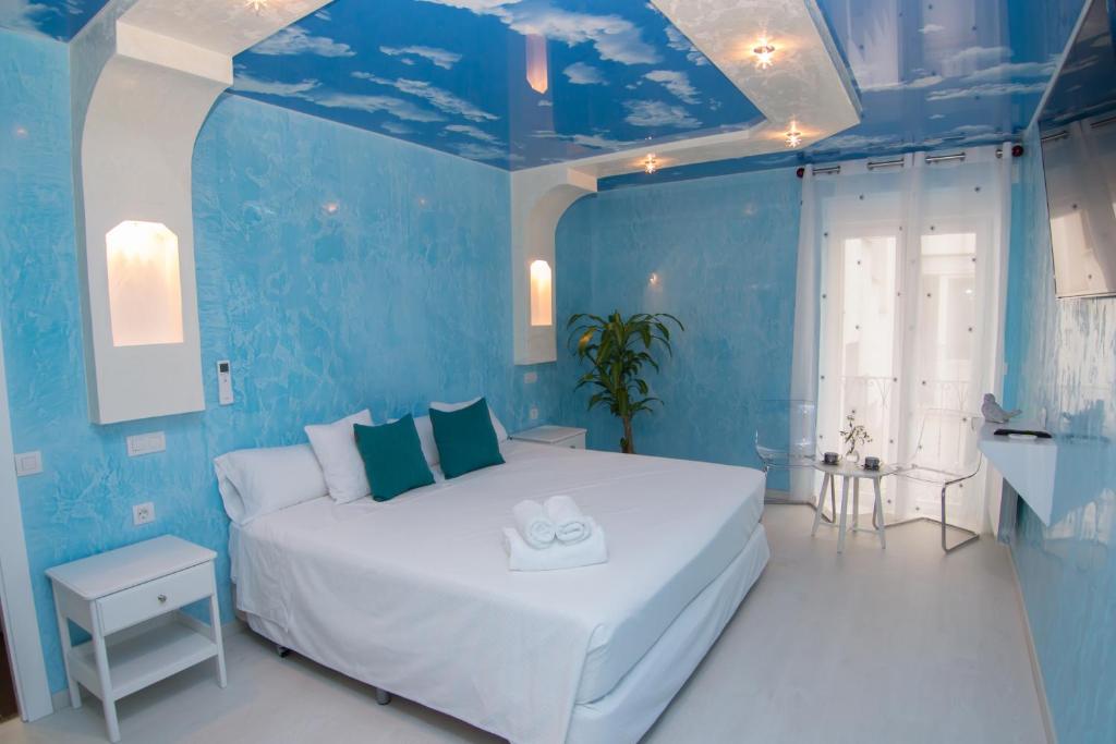 Dormitorio azul con cama blanca y paredes azules en Hostal Palacio Madrid, en Madrid