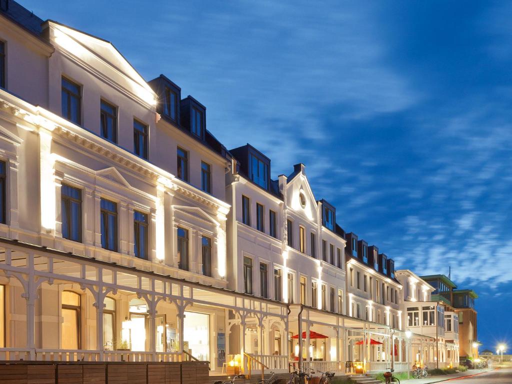 a row of white buildings on a street at night at Inselloft Norderney in Norderney