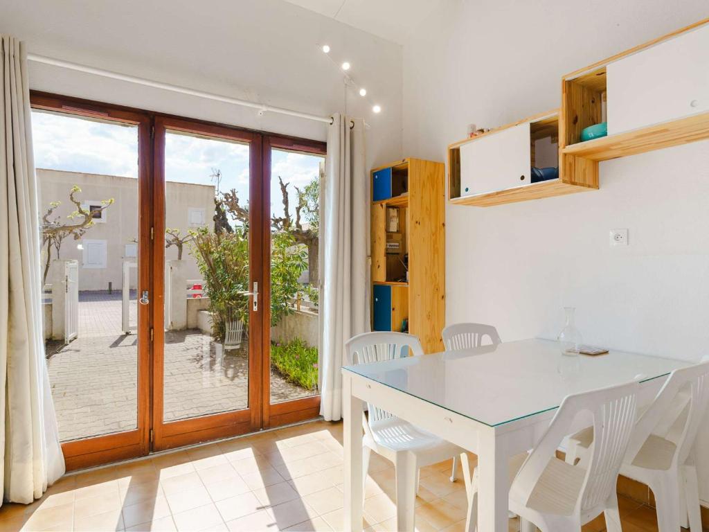 une salle à manger blanche avec une table et des chaises blanches dans l'établissement Pavillon 2 pièces mezzanine, piscine proche plage, parking privé - FR-1-409-98, à Narbonne-Plage