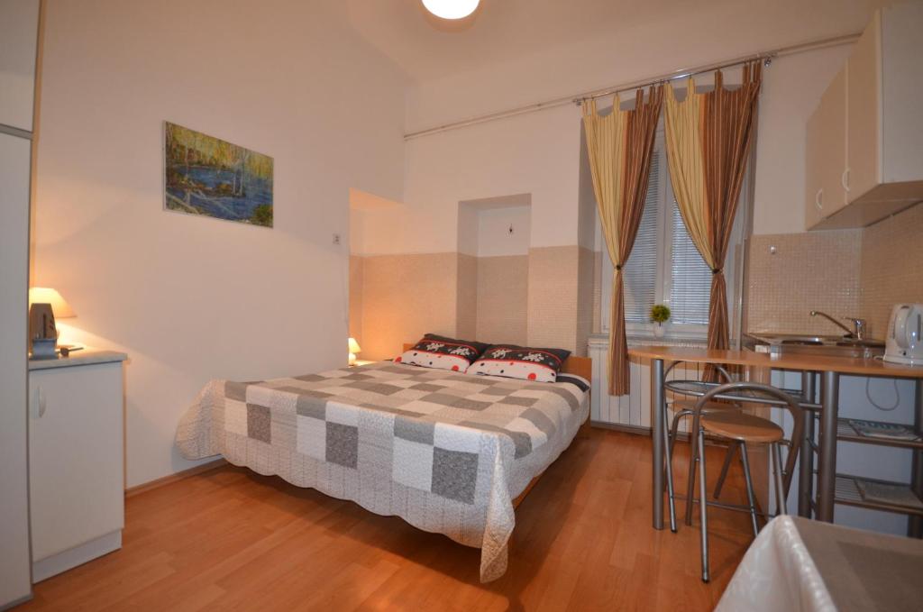 Un pequeño dormitorio con una cama y una cocina. en Apartment Porto Baross, en Rijeka