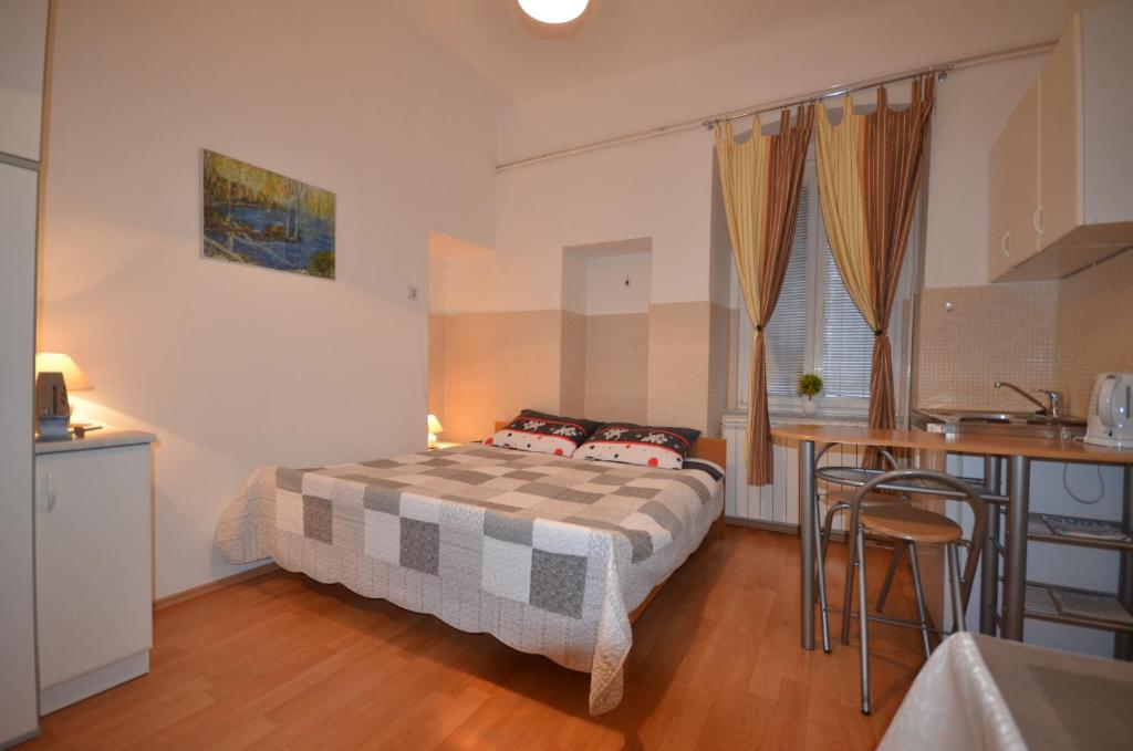 a small bedroom with a bed and a kitchen at Apartment Porto Baross in Rijeka