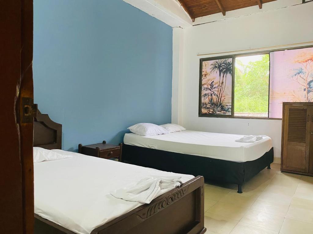 um quarto com duas camas e uma janela em Apartamento frente al mar entre Tolu y Coveñas em Puerto Viejo