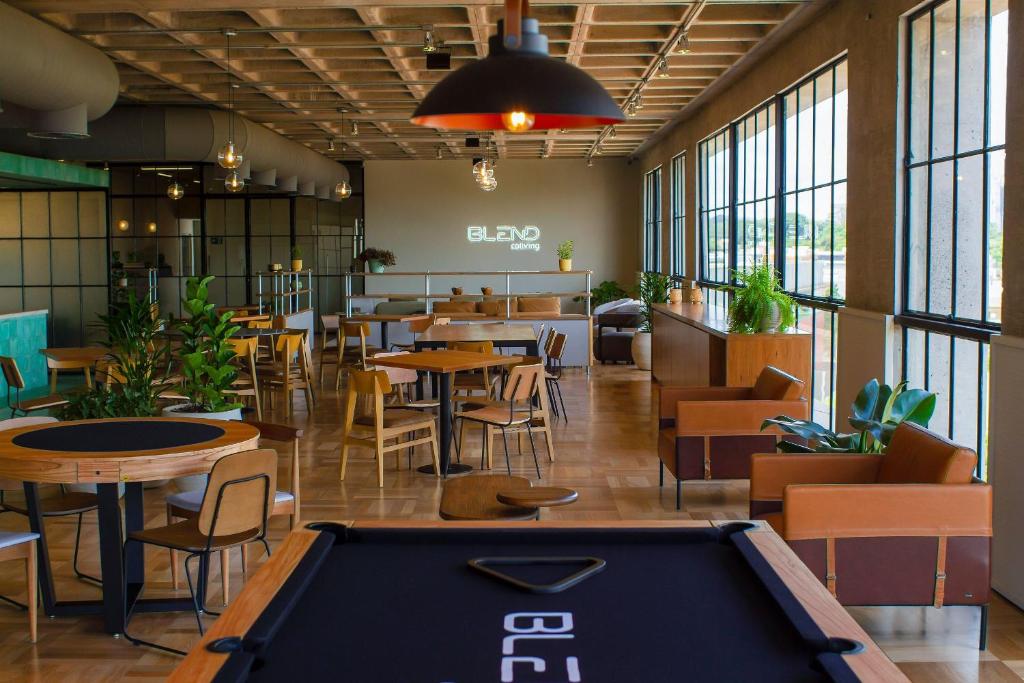 ein Billardtisch in einem Restaurant mit Tischen und Stühlen in der Unterkunft Blend Coliving One - 3b in Ribeirão Preto