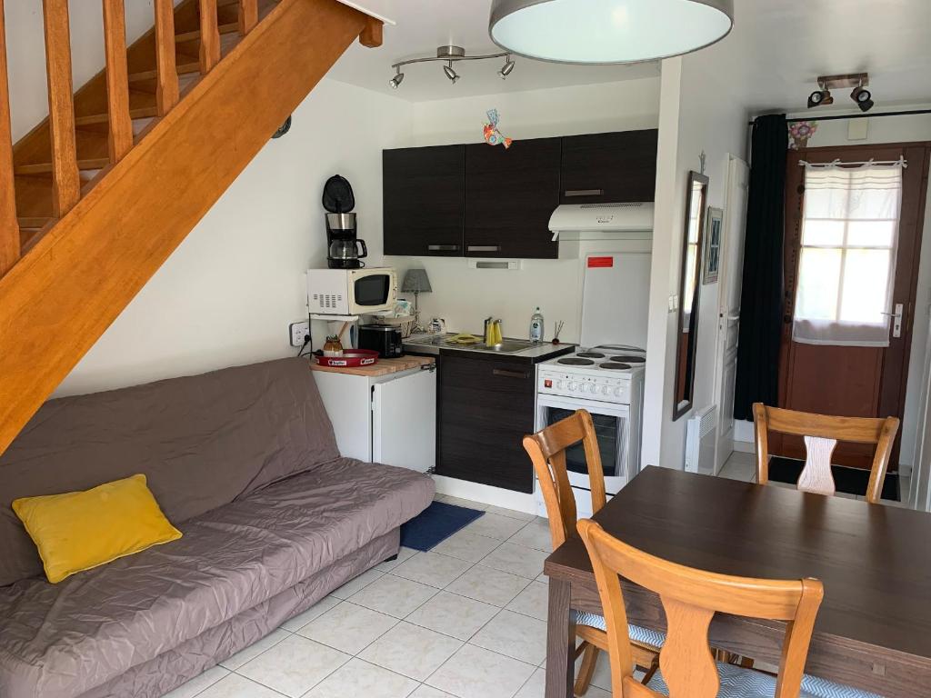 un salon avec un canapé et une table et une cuisine dans l'établissement Charmante Maisonnette avec Jardin, Proche Plage et Commerces à Fort-Mahon-Plage - FR-1-482-144, à Fort-Mahon-Plage