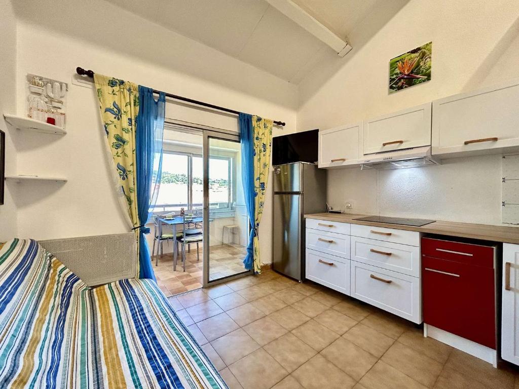 une cuisine avec des placards blancs et une grande fenêtre dans l'établissement Sainte-Maxime: Studio Mezzanine 4 Couchages à 50m de la Plage - FR-1-226-547, à Sainte-Maxime