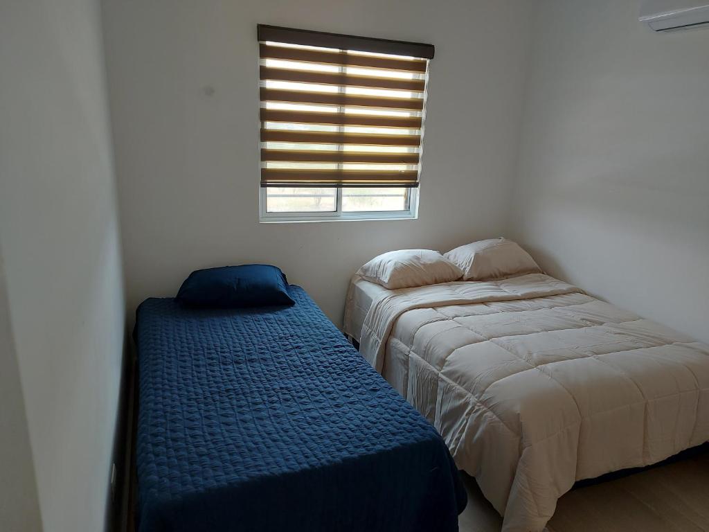 um quarto com 2 camas e uma janela em Alojamiento Entero Monterrey Airport em Monterrey