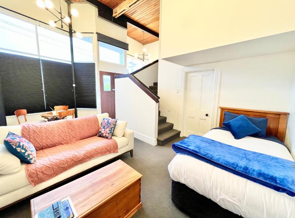 a bedroom with a bed and a couch at Opoho Heritage Guest Suite in Dunedin