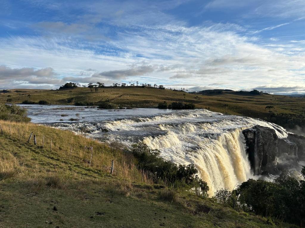 a waterfall in the middle of a field at Cabanas Rural Colina Do Sol in Cambará