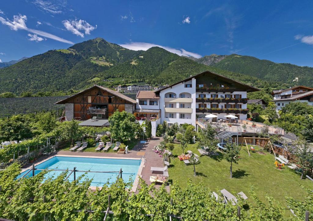 un complejo con piscina y montañas de fondo en Garni-Hotel Tritscherhof, en Tirolo