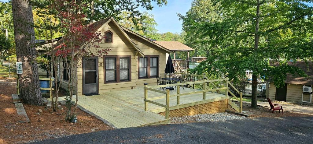 a house with a wooden deck in front of it at #06 - Lakeview Two Bedroom Cottage-Pet Friendly in Hot Springs
