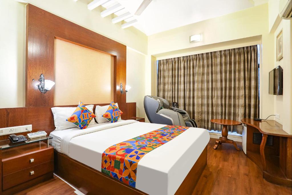 a hotel room with a bed and a desk and a desk at FabHotel Shubhangan in Mumbai