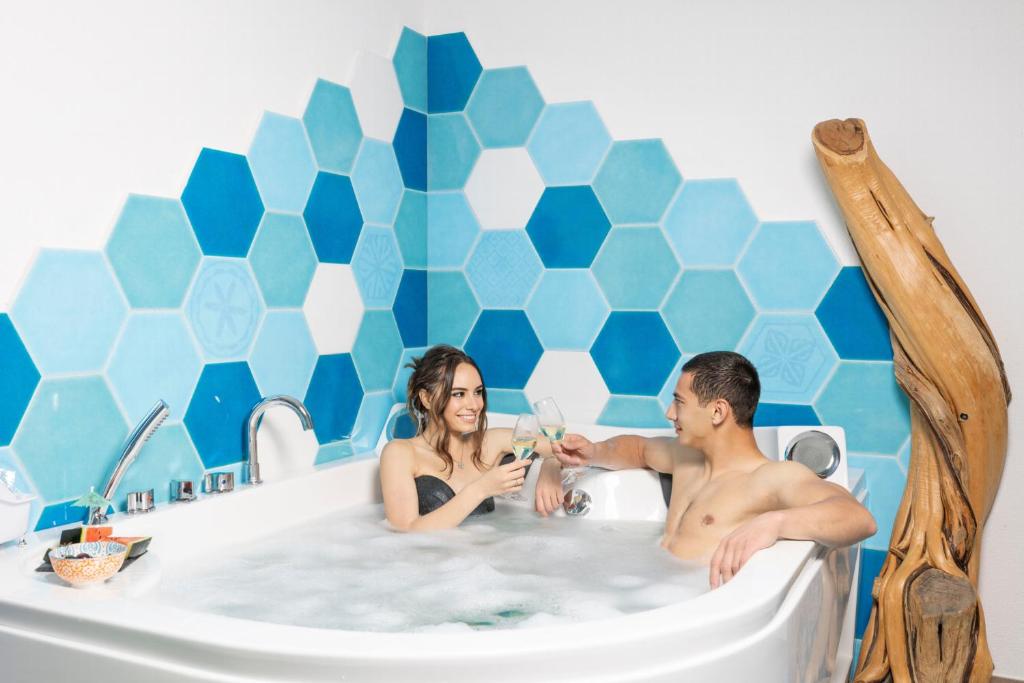 un hombre y una mujer sentados en una bañera en Agua Dorada Boutique en Lula