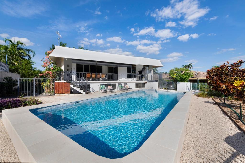 a villa with a swimming pool in front of a house at 'Arafura Blue' a Poolside Family Oasis on the Coast in Darwin