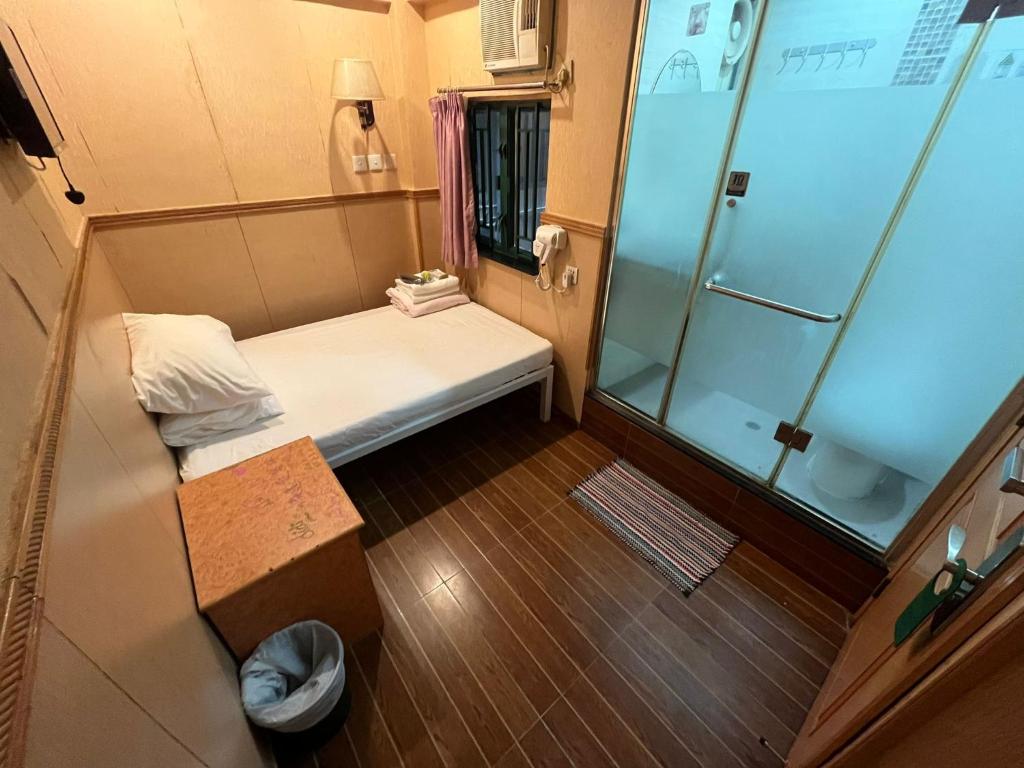 Habitación pequeña con ducha y cama en USA Hostel HONG KONG, en Hong Kong