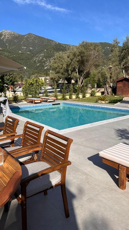 a swimming pool with two chairs and a table at The White Villa in Nydri