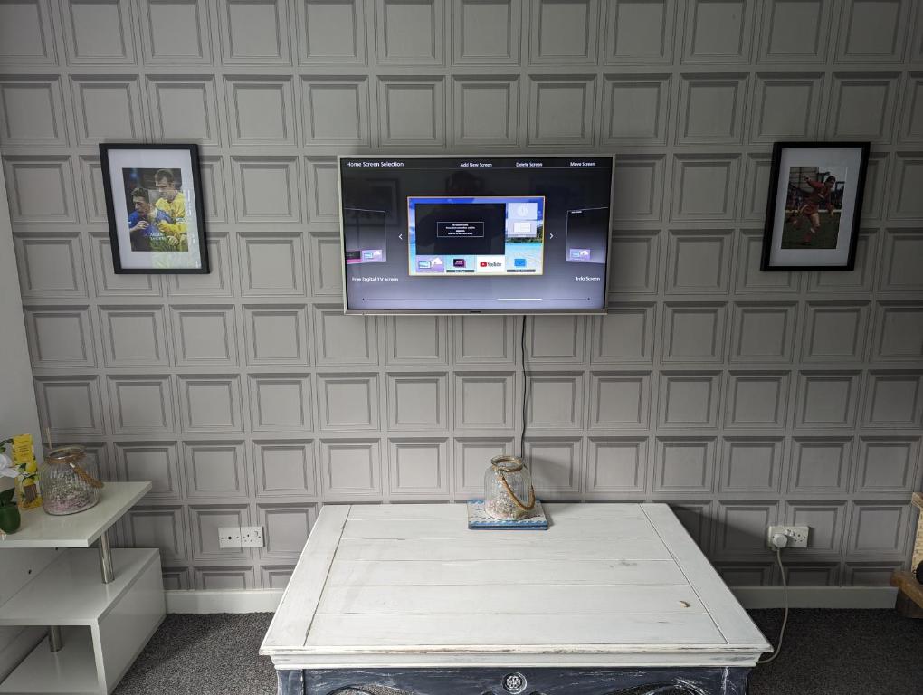 Zimmer mit einem Wand-TV und einem Tisch in der Unterkunft Above us only sky in Kirkby