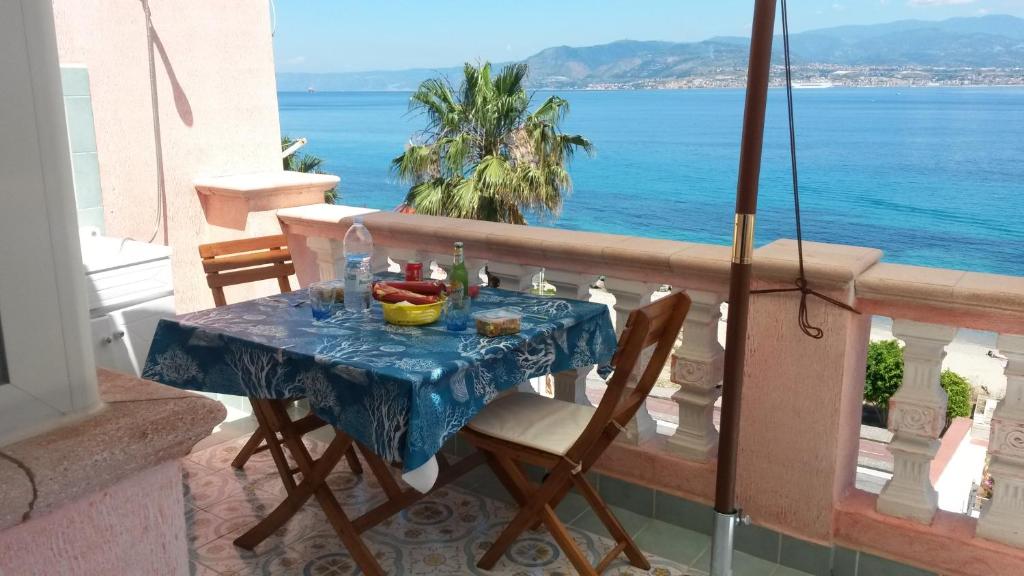 una mesa en un balcón con vistas al océano en Blue Eden Strait, en Messina