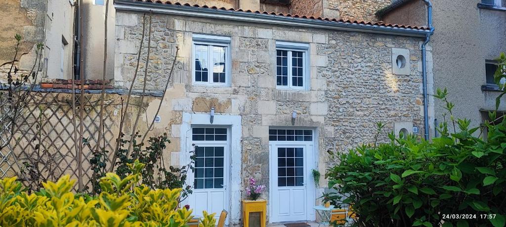 Cette ancienne maison en pierre est dotée de portes et de fenêtres blanches. dans l'établissement Le CocoOn Doré, à Poitiers