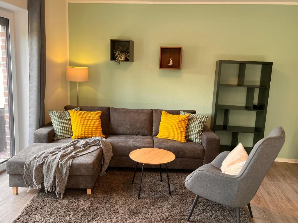 uma sala de estar com um sofá e uma cadeira em Neues Apartment Nordisch bei Nature by Fewo & Zimmer Bruns em Emden