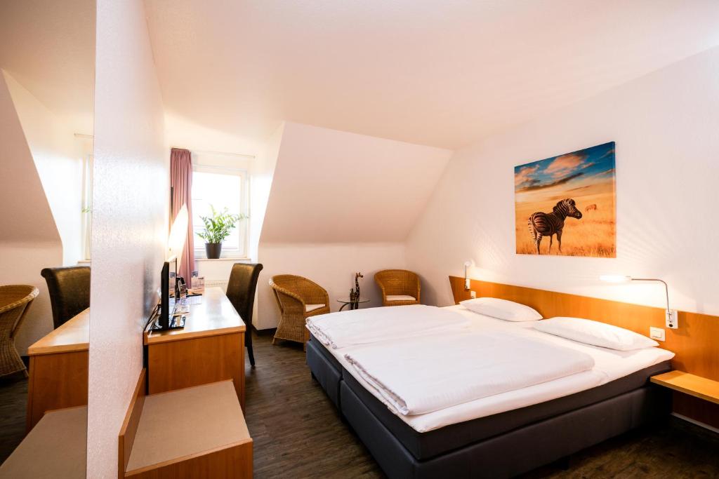 um quarto de hotel com uma cama e uma secretária em hogh Hotel Heilbronn em Heilbronn