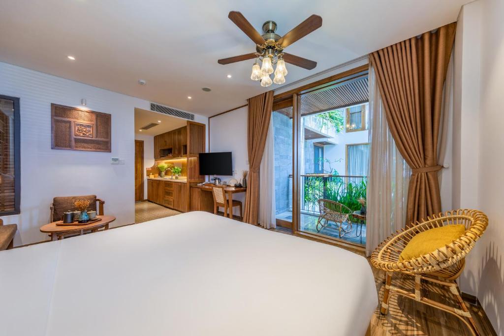 Schlafzimmer mit einem Bett und einem Deckenventilator in der Unterkunft Bonny Boutique Hotel Da Nang in Đà Nẵng