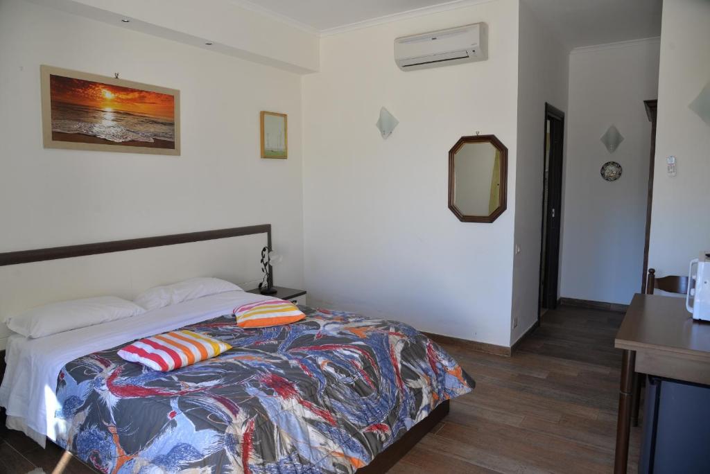 ein Schlafzimmer mit einem Bett mit einer bunten Bettdecke in der Unterkunft La Tenuta del Passero in Le Ferriere