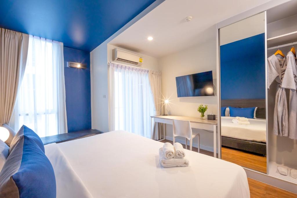 a hotel room with a bed and a mirror at Blue Hippo Hotel in Ban Khlong Samrong