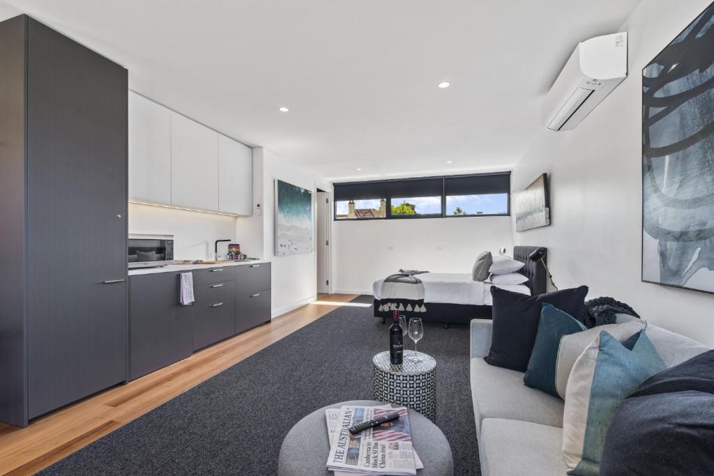 a living room with a couch and a kitchen at Stylish Studio with Great Amenities near Beachside in Melbourne