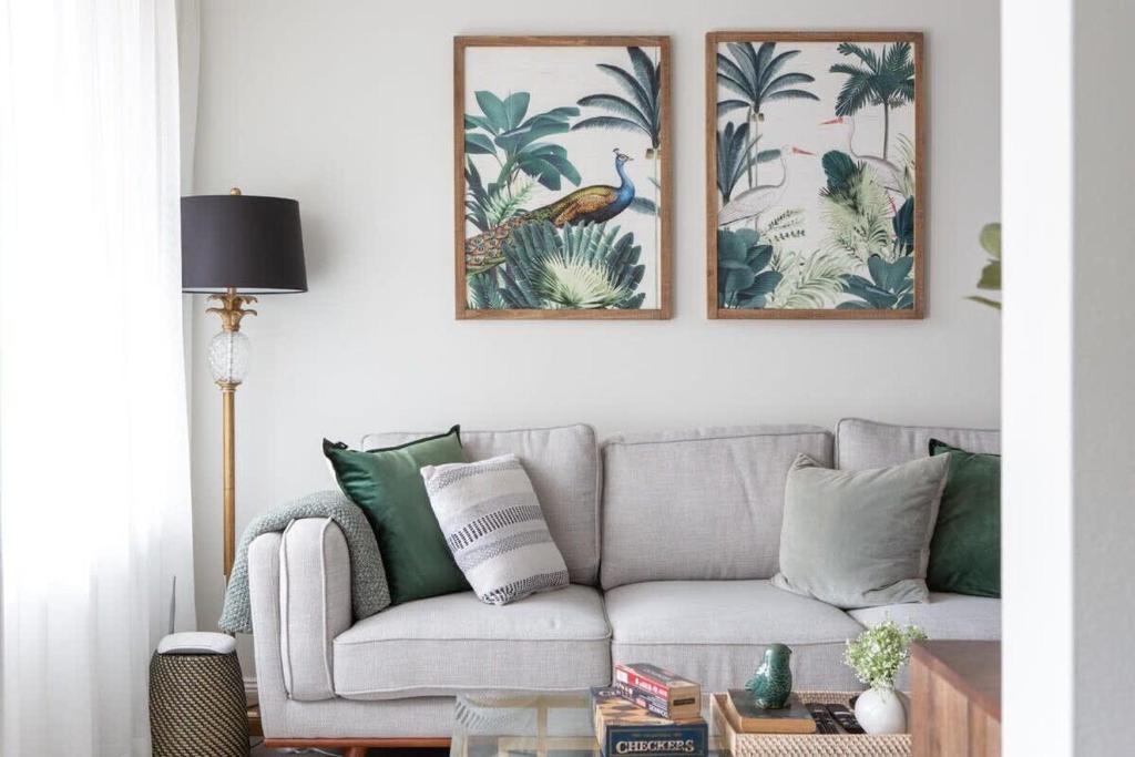 a living room with a gray couch and two framed pictures at Sunny Apartment in Quiet and Green Neighbourhood in Sydney
