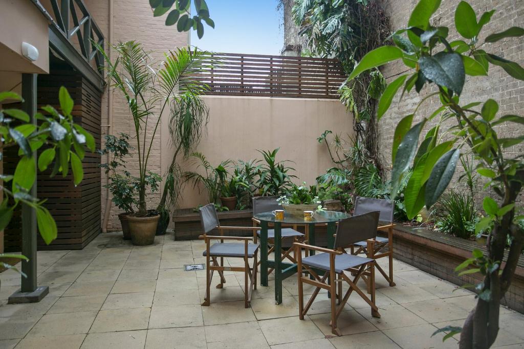 un patio con tavolo, sedie e piante di Family Terrace Home Close to Oxford Street and CBD a Sydney