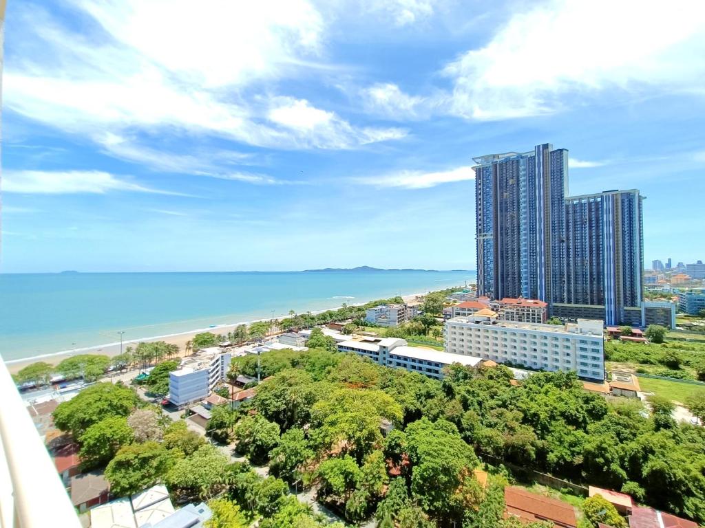 uma vista para uma cidade com um edifício alto e o oceano em Sea View Beachfront Condos Pattaya Jomtien Beach em Praia de Jomtien
