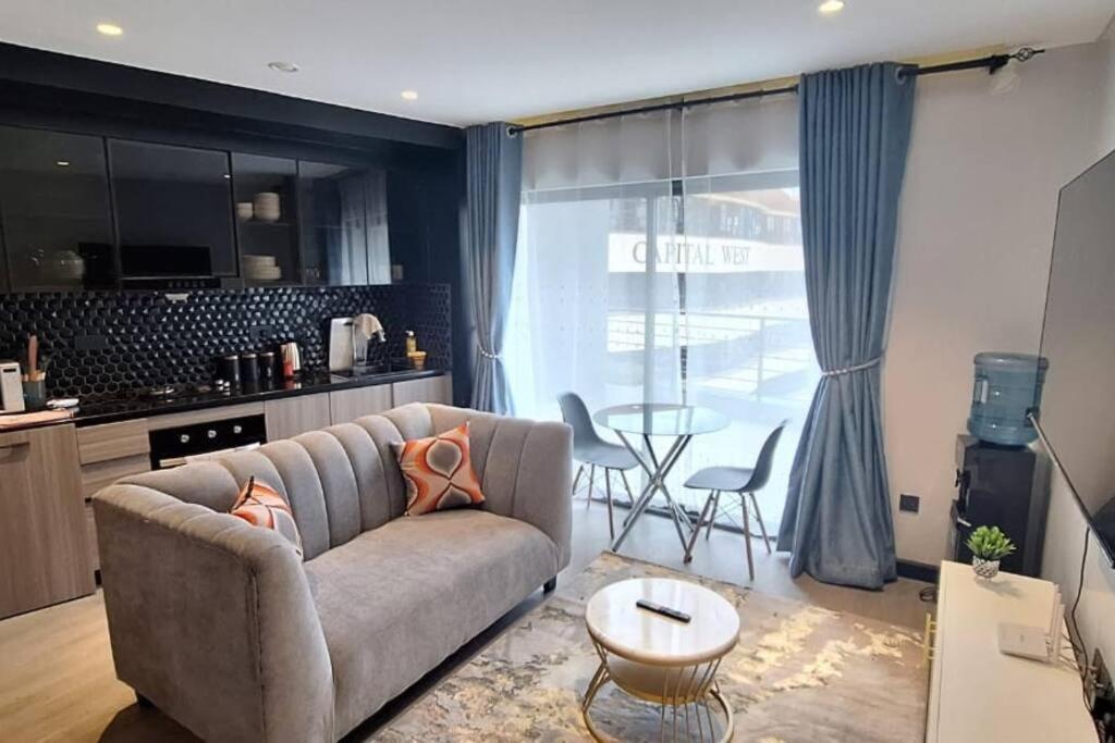 a living room with a couch and a table at Urban Oasis Studio Apartment in Nairobi