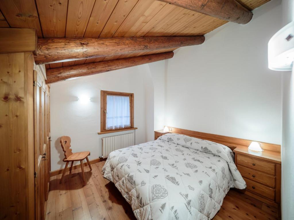sypialnia z łóżkiem i drewnianym sufitem w obiekcie Villa Lacedel - Stayincortina w mieście Cortina dʼAmpezzo