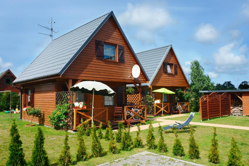 JezierzanyにあるCAŁOROCZNE DOMKI NAD MORZEM I JEZIOREMの庭付きの大きな木造家屋
