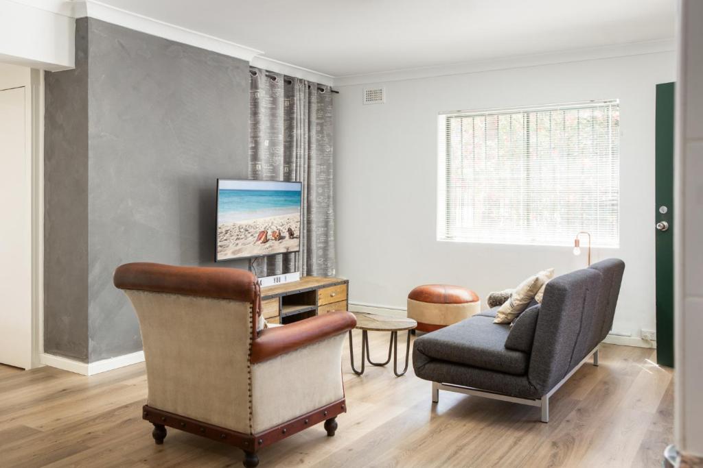 un soggiorno con divano e sedia di Suburban Two-bed Apartment with Parking and Patio a Sydney