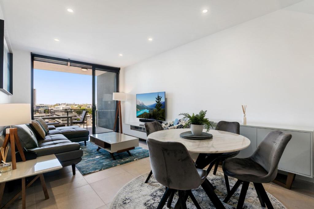 sala de estar con mesa, sillas y sofá en Convenient 2-Bed Apartment with Panoramic Views en Brisbane