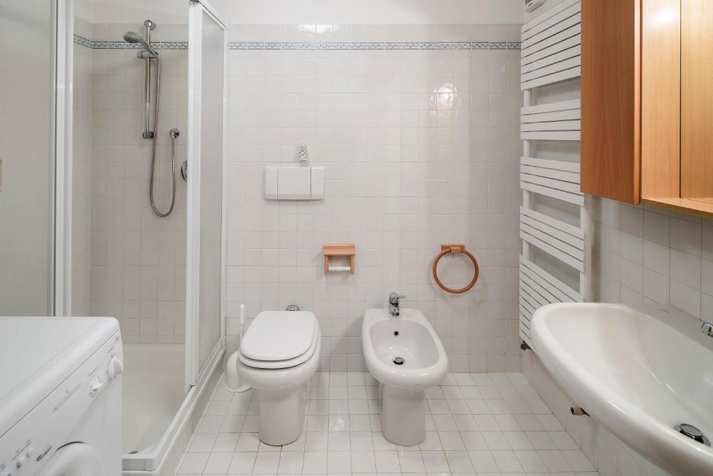 biała łazienka z toaletą i umywalką w obiekcie Villa Lacedel - Stayincortina w mieście Cortina dʼAmpezzo