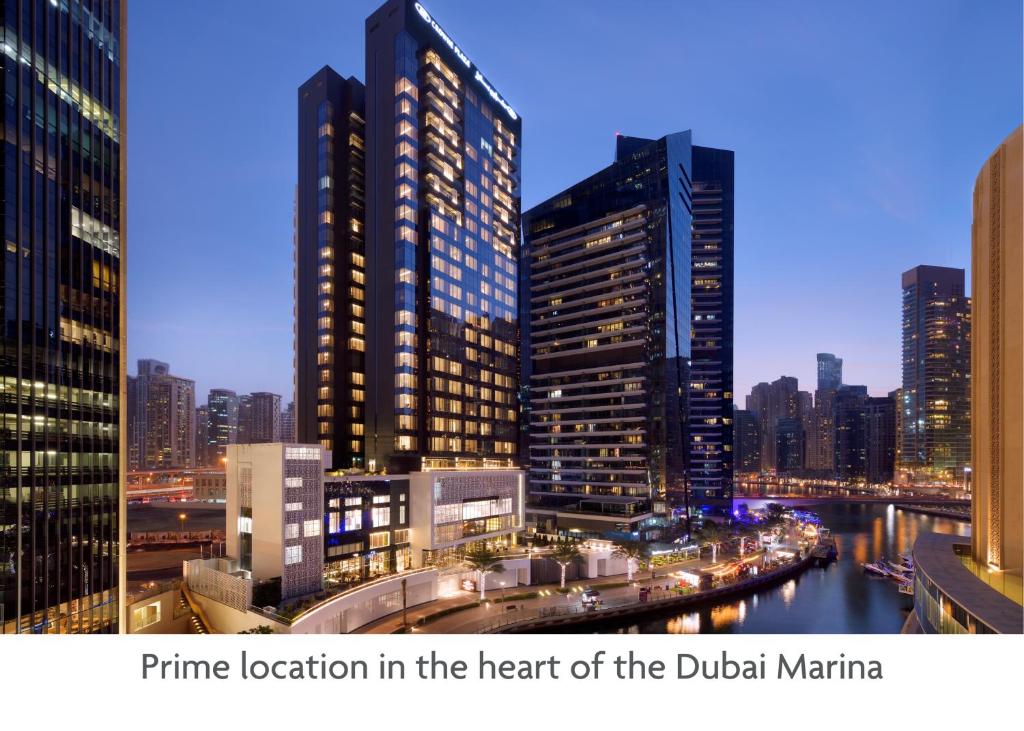Crowne Plaza Dubai Marina, an IHG Hotel في دبي: اطلاله على مدينه بالليل بالمباني