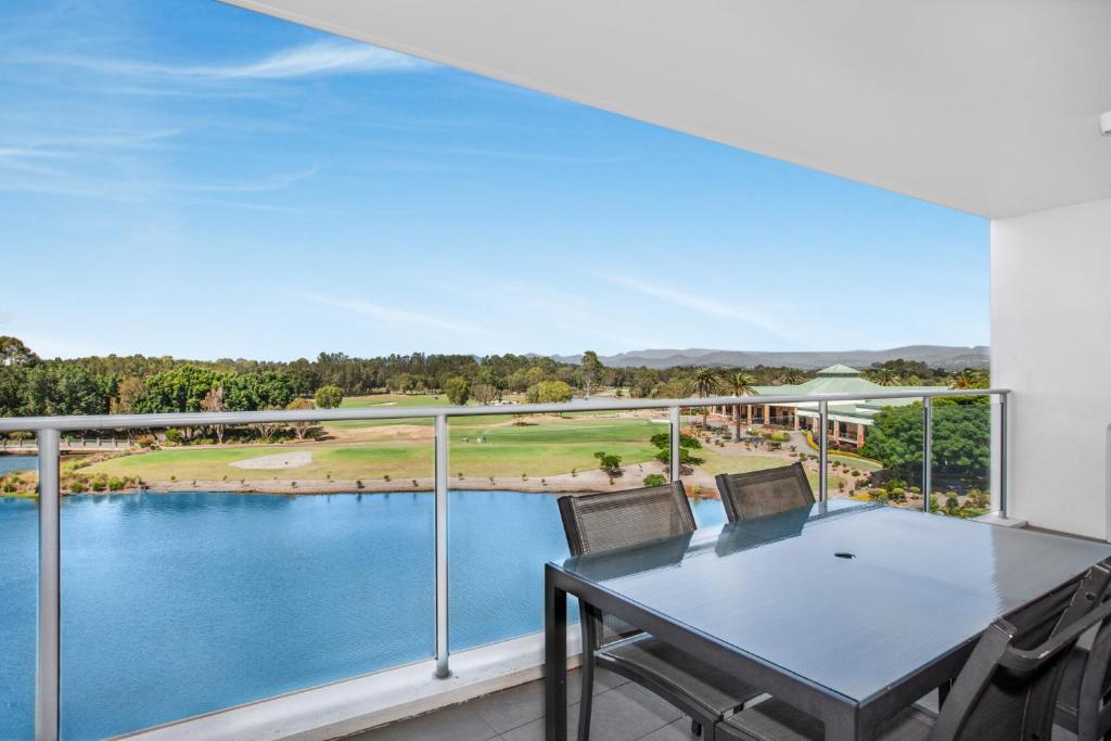 a view from the balcony of a house with a table and chairs at Lakeside Family Oasis with Pool, Gym and Balcony in Gold Coast