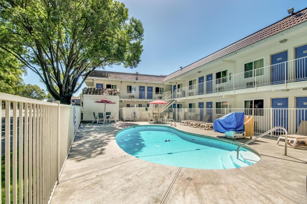 a swimming pool in the courtyard of a apartment building at Motel 6-Stockton, CA - North in Lincoln Village