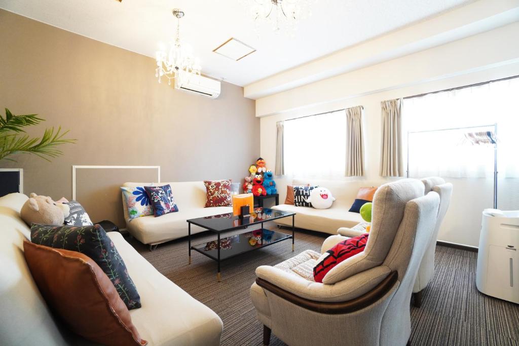 Sala de estar con 2 sofás y mesa en Sakurajima Parkside House A en Osaka