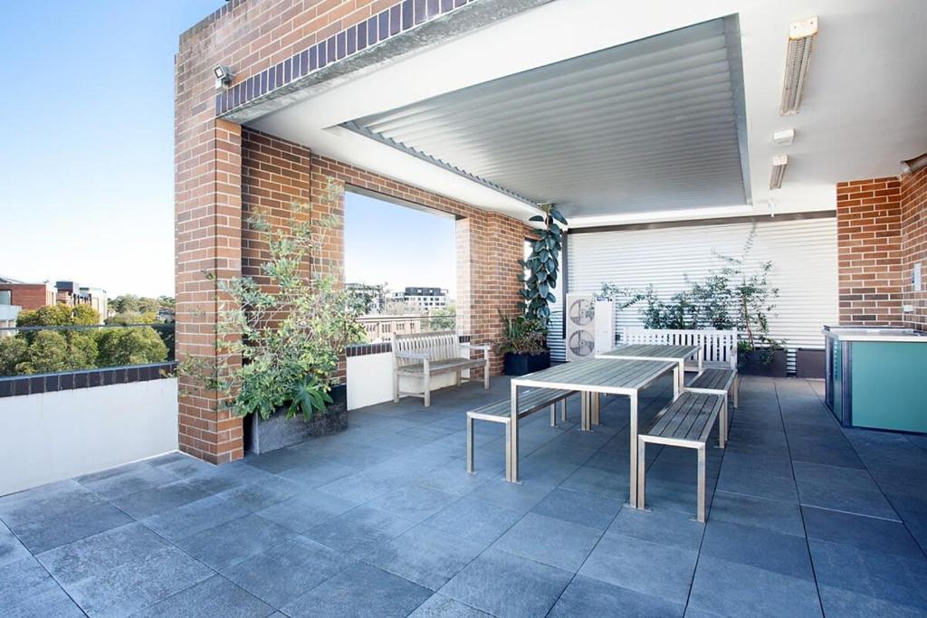a patio with a table and chairs on a building at Stylish Studio with Balcony near Darling Square in Sydney
