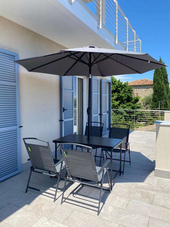 een tafel en stoelen onder een parasol op een terras bij Orizzonte in Loano