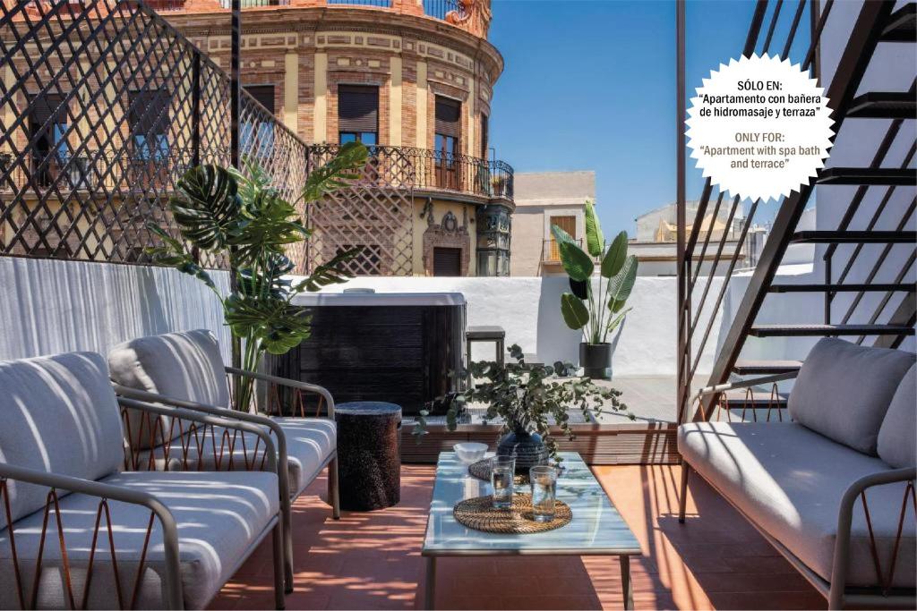 d'une terrasse avec des chaises, une table et une cheminée. dans l'établissement Suites Maestranza - Puerta del Arenal by Magno Apartments, à Séville