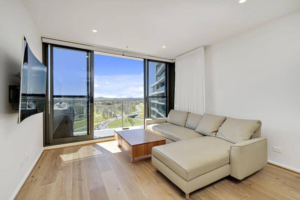 sala de estar con sofá y ventana grande en Modern 1-Bed Apartment With Parking, Pool and Gym, en Phillip